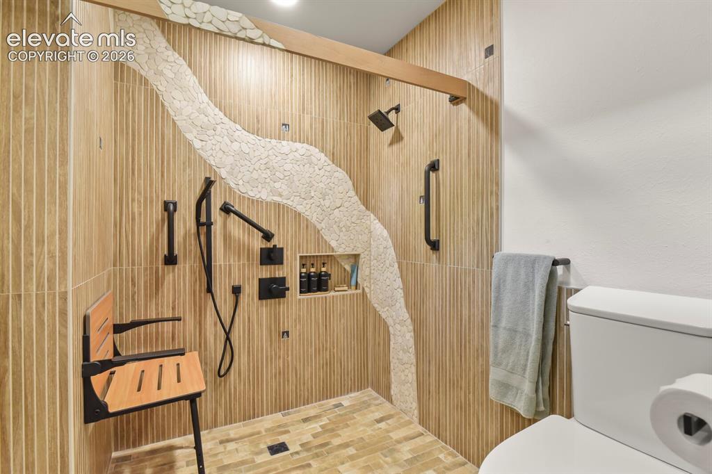 Image 36 of 50: Newly updated 3/4 bathroom with modern custom surround tile, hardware, tile