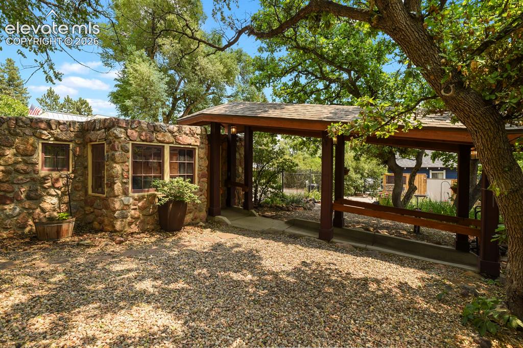 Image 7 of 50: Detached two car stone exterior garage with custom breezeway