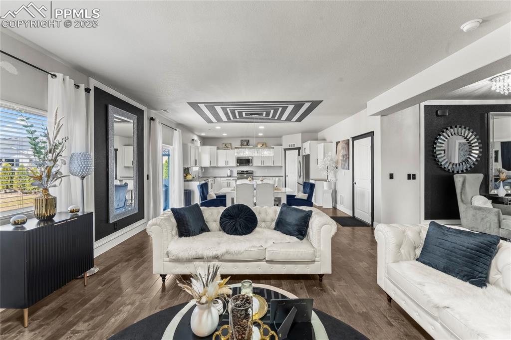 Image 10 of 39: Living room with dark wood-style flooring and baseboards