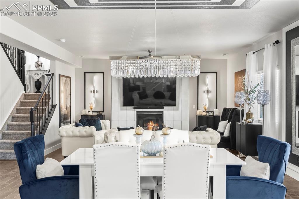 Image 15 of 39: Dining area featuring a glass covered fireplace, stairway, and wood finishe