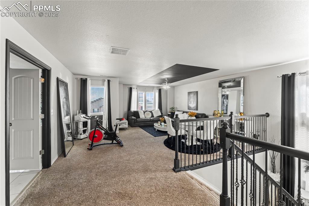Image 18 of 39: Workout area with a textured ceiling and light colored carpet