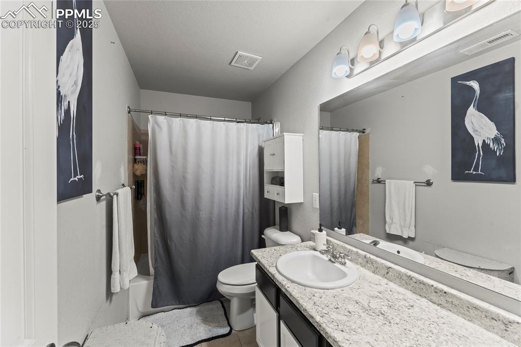 Image 27 of 39: Full bath with vanity, shower / bath combo with shower curtain, and light t