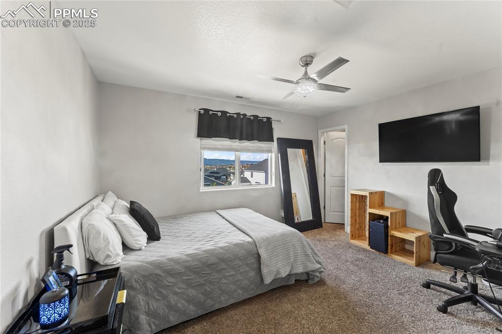 Image 28 of 39: Bedroom with carpet flooring, a ceiling fan, a textured ceiling, and an off