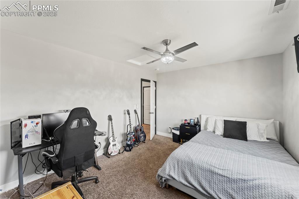Image 29 of 39: Bedroom with ceiling fan, carpet floors, and an office area
