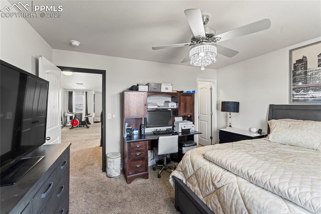 Image 31 of 39: Bedroom with light colored carpet, an office area, and ceiling fan