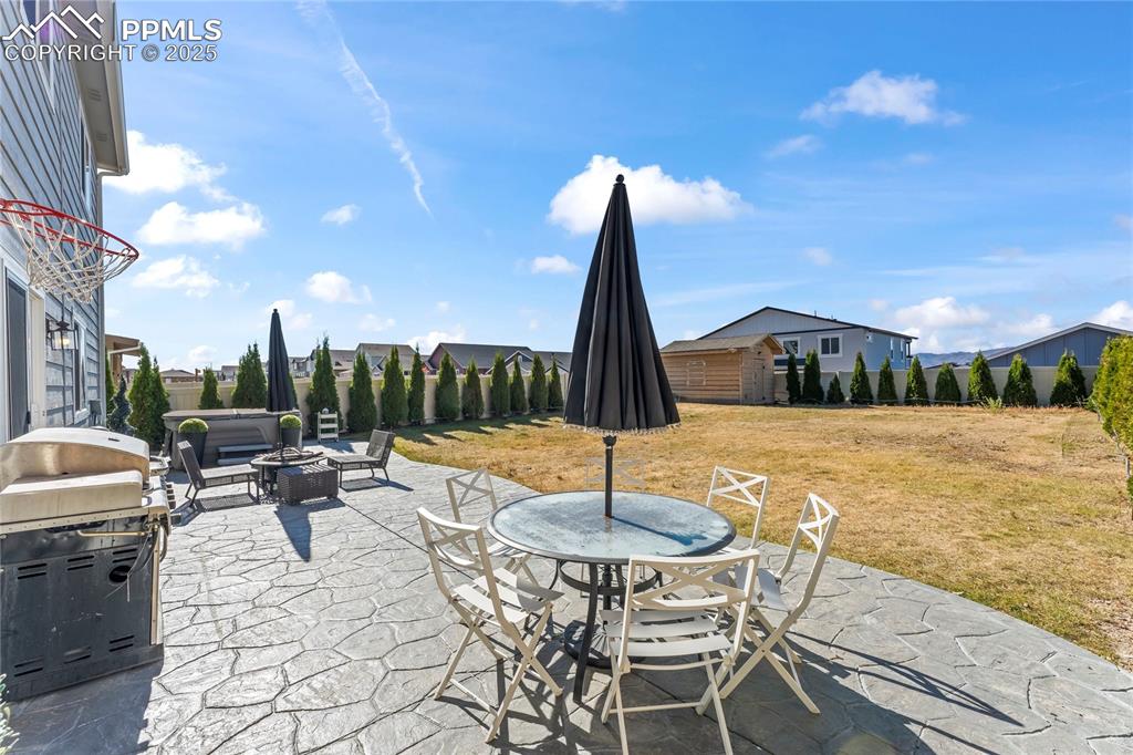 Image 32 of 39: View of patio featuring an outdoor fire pit, outdoor dining space, and gril