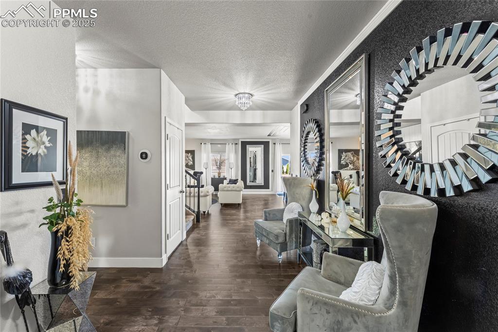 Image 4 of 39: Hall with dark wood-style floors, a textured ceiling, and stairs