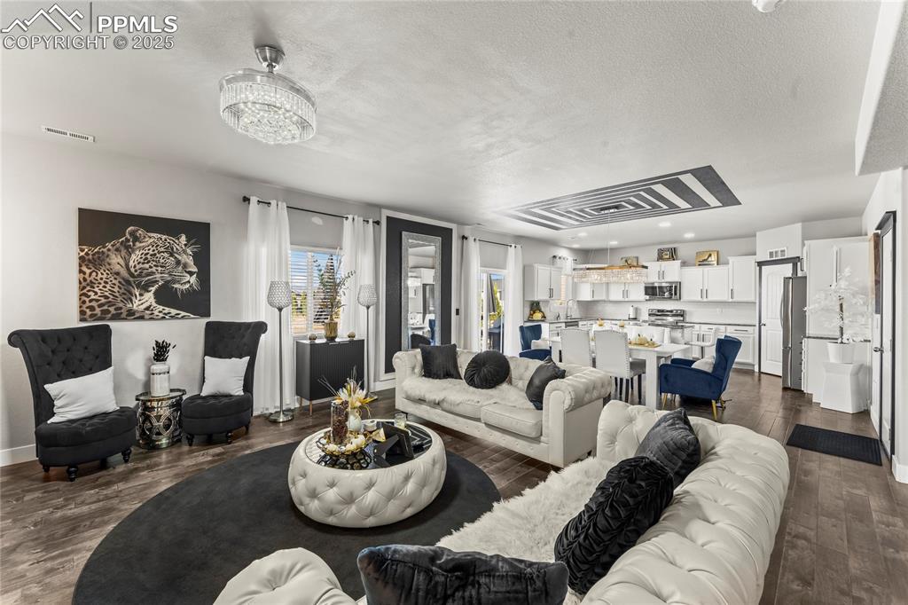 Image 8 of 39: Living area featuring dark wood-type flooring and a textured ceiling
