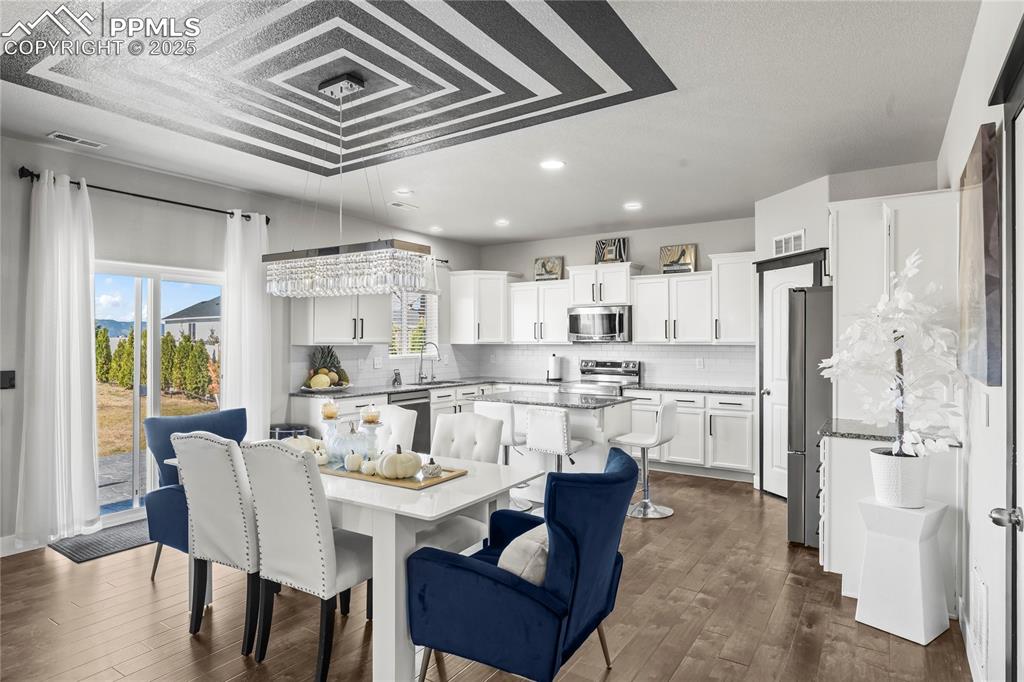 Image 9 of 39: Dining area with recessed lighting and dark wood finished floors