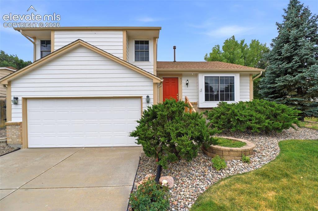 Image 1 of 50: White siding exterior with a prominent two-car garage, a vibrant red entry
