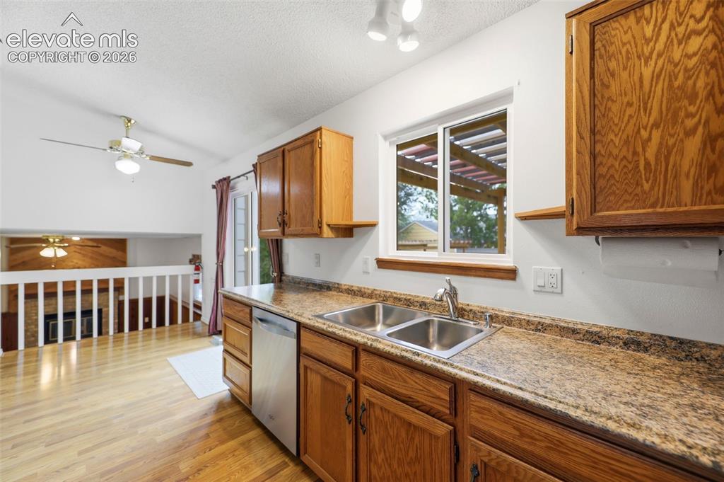 Image 16 of 50: Kitchen featuring wood-finish cabinetry, a double basin stainless steel sin