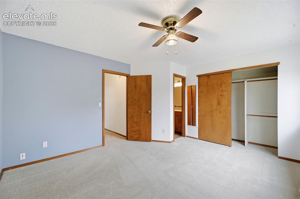 Image 25 of 50: Carpeted room featuring a ceiling fan with integrated lighting, wood-finish
