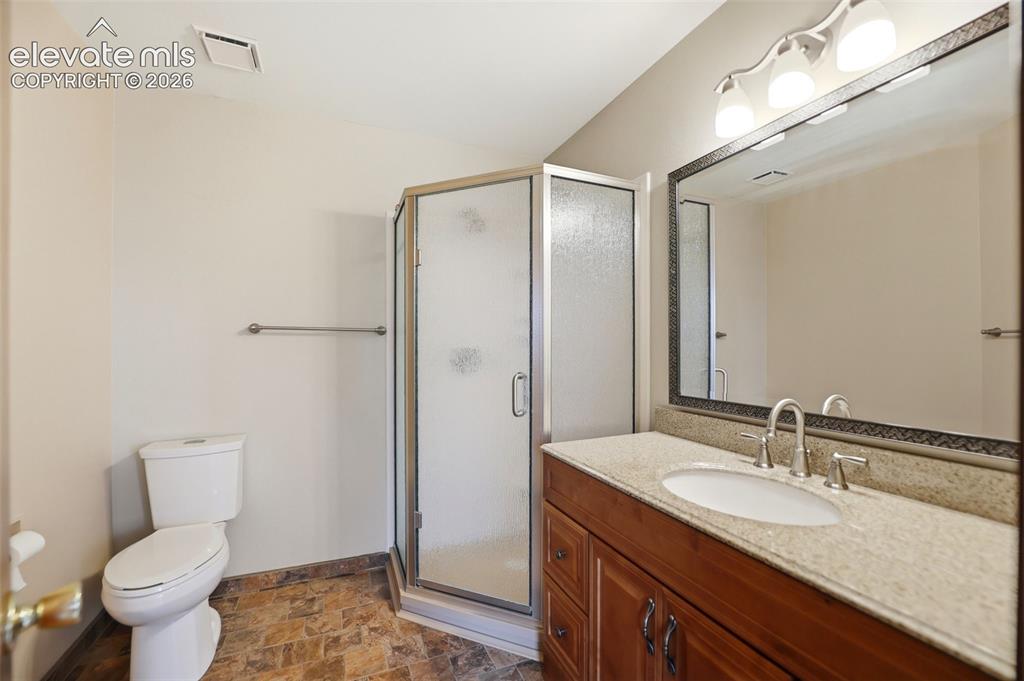 Image 26 of 50: Bathroom featuring a corner shower with frosted glass enclosure, a vanity w