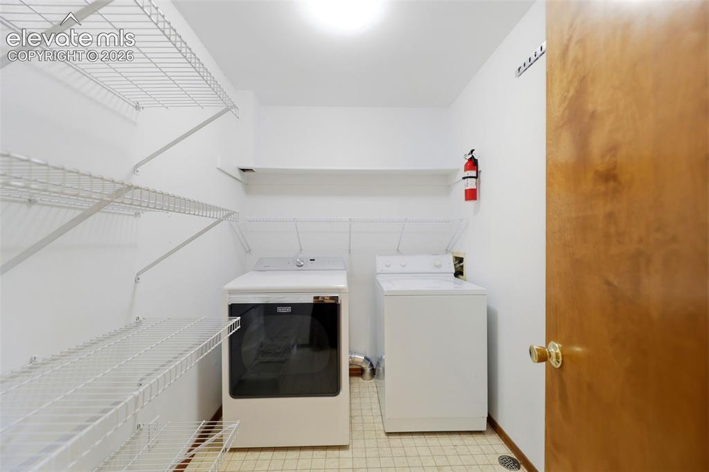 Image 27 of 50: Laundry room featuring white wire shelving, a built-in wall shelf, light-co