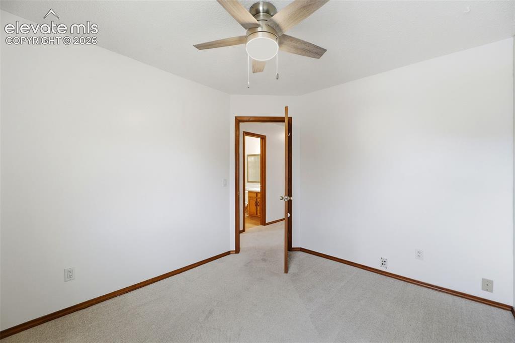 Image 30 of 50: Carpeted room with white walls and natural wood trim
