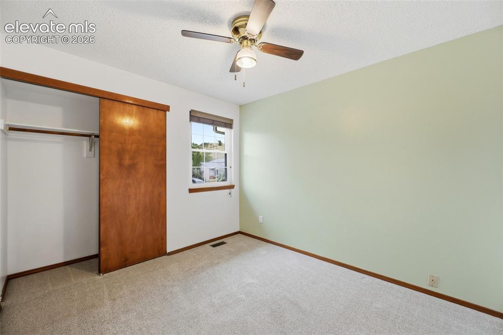 Image 31 of 50: Room featuring light green and white walls, neutral carpet, and a brass-fin