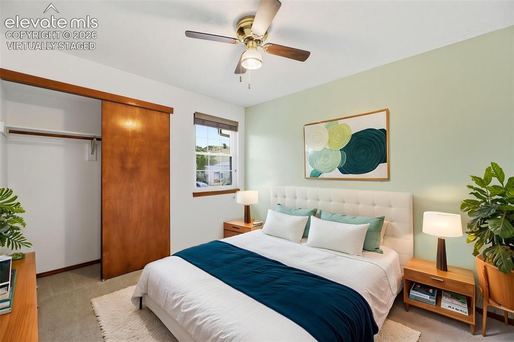 Image 32 of 50: Virtually Staged - Bedroom featuring a ceiling fan, a window with a roller