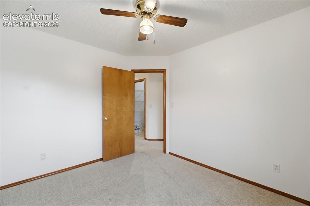 Image 33 of 50: Carpeted interior space featuring a ceiling fan with light fixture, white w