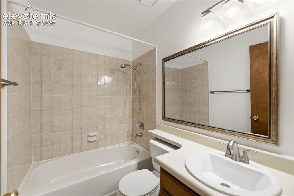 Image 34 of 50: Bathroom featuring a tiled tub/shower combination, a vanity with an integra