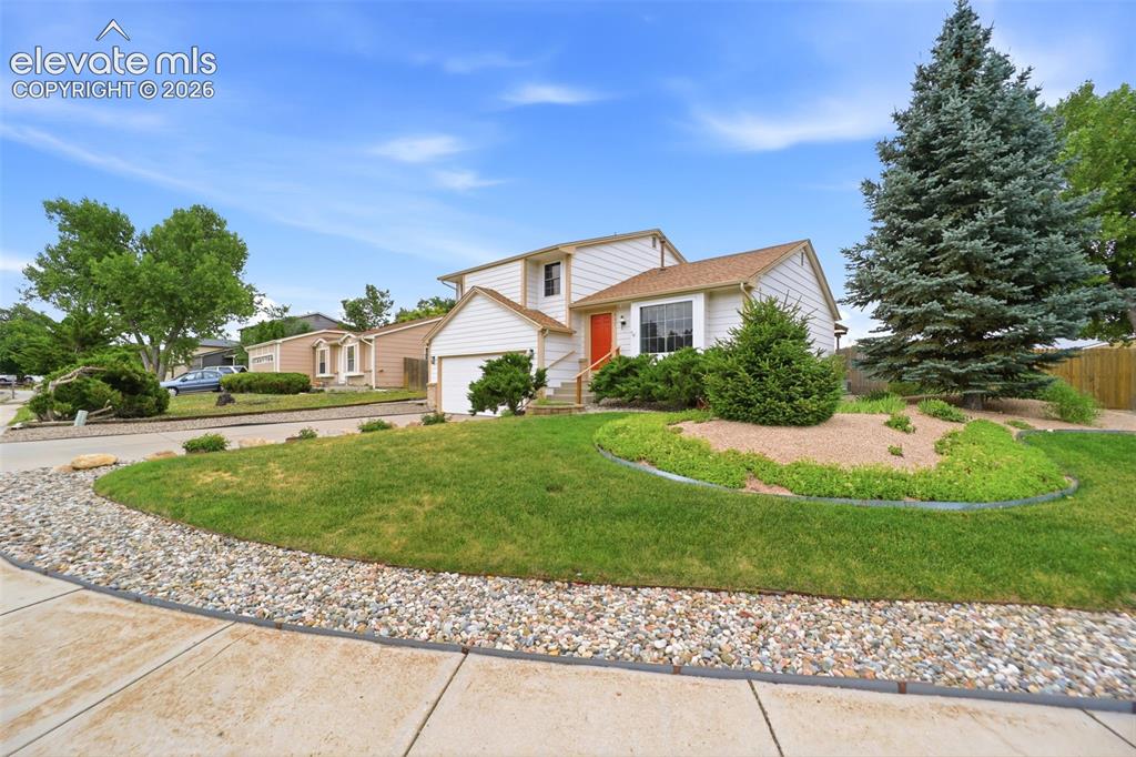 Image 4 of 50: White siding exterior with a single-car garage, an orange entry door, and a