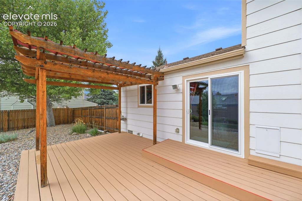 Image 42 of 50: Expansive outdoor deck featuring wood-finish flooring and an integrated per