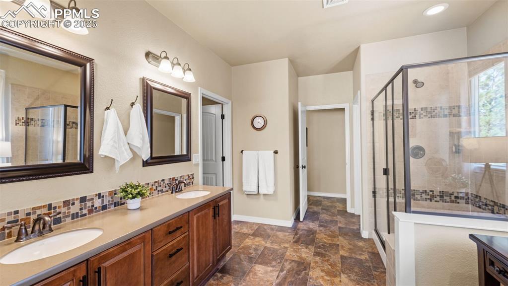 Image 24 of 48: Dual sinks, a roomy shower, and a walk-in closet to match.