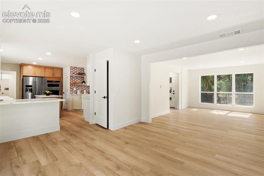 Image 10 of 43: Unfurnished living room with light wood finished floors and recessed lighti