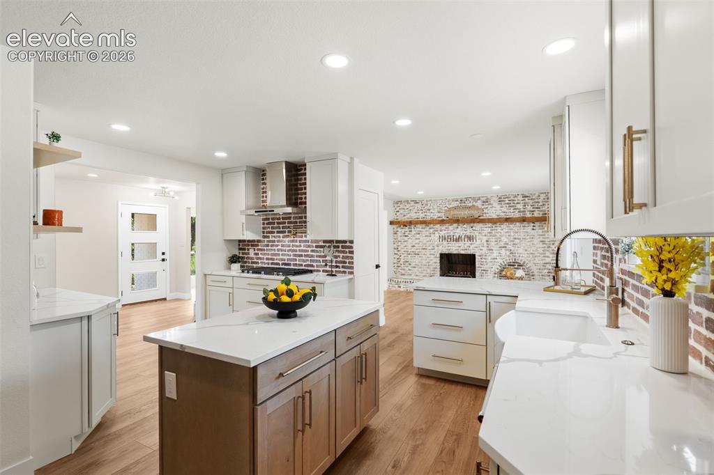 Image 15 of 43: Kitchen with light stone countertops, recessed lighting, open shelves, ligh