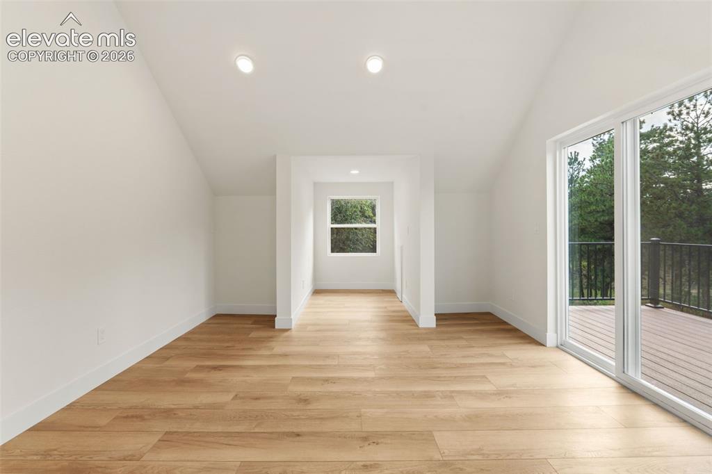 Image 20 of 43: Mater bedroom featuring lofted ceiling, recessed lighting, and light wood-s
