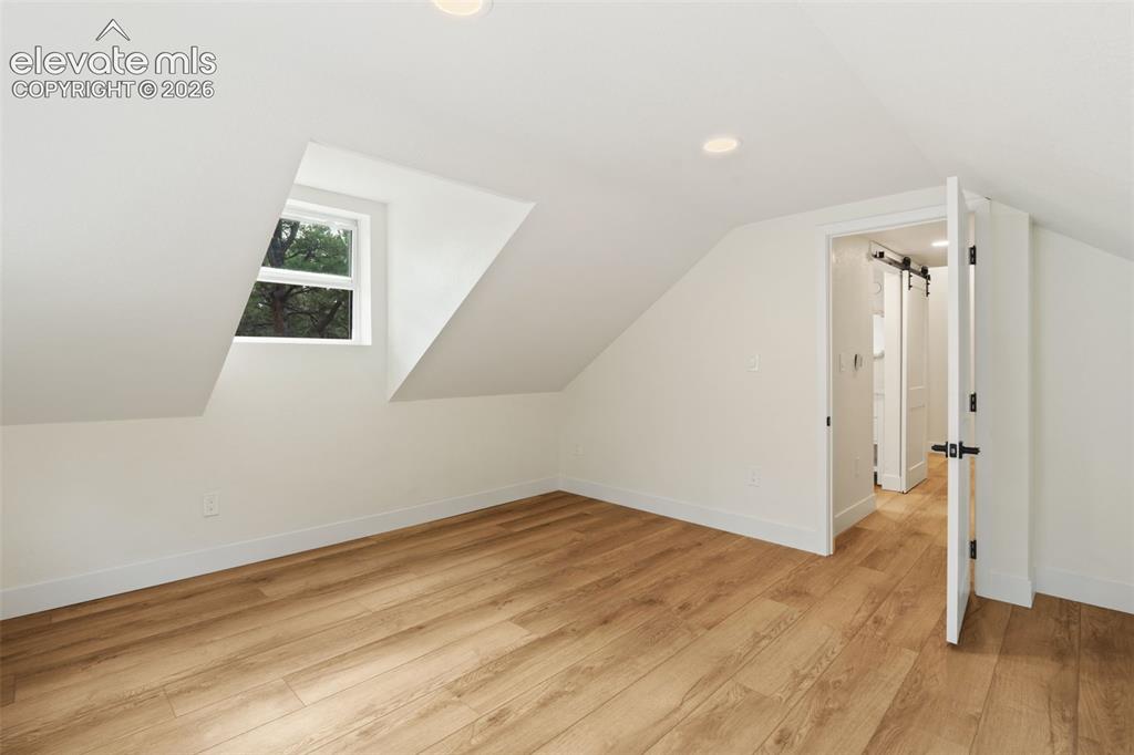 Image 26 of 43: Bonus room with light wood-style flooring, recessed lighting, vaulted ceili