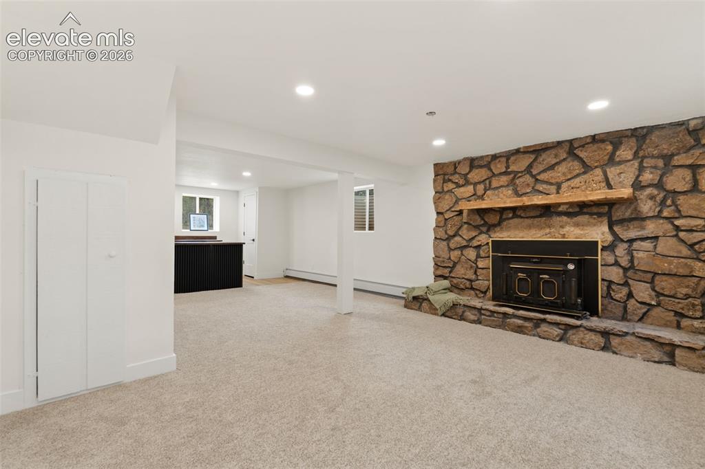 Image 31 of 43: Unfurnished living room featuring recessed lighting, light carpet, and a fi