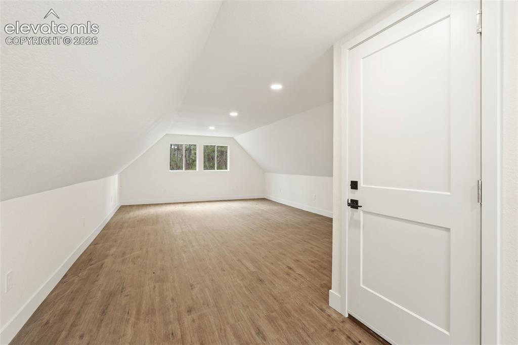 Image 39 of 43: Bonus room featuring light wood-style floors, vaulted ceiling, and recessed