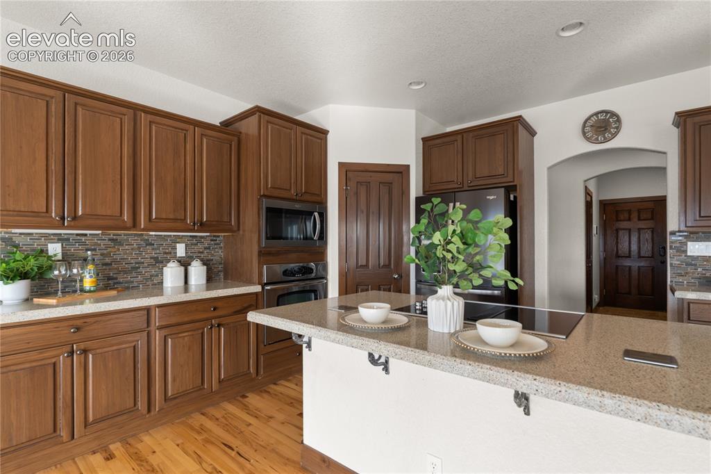 Image 16 of 40: Kitchen with stainless steel appliances, solid surface countertops, and ins