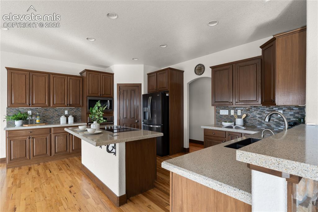 Image 9 of 40: The kitchen has space to eat at multiple islands, a large pantry, solid sur