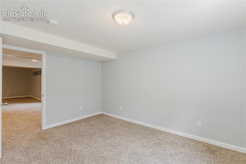 Image 19 of 46: Neutral tone wall paint with matching trim, textured carpet flooring, and a