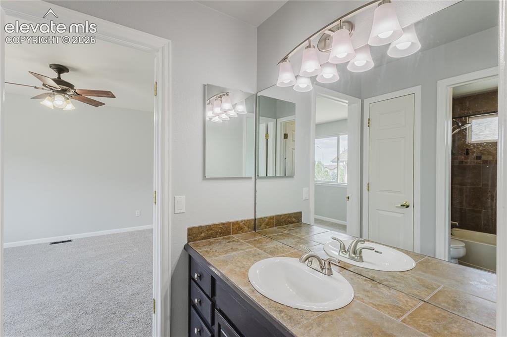 Image 26 of 46: Double vanity with integrated sinks and brushed nickel faucets, tile counte