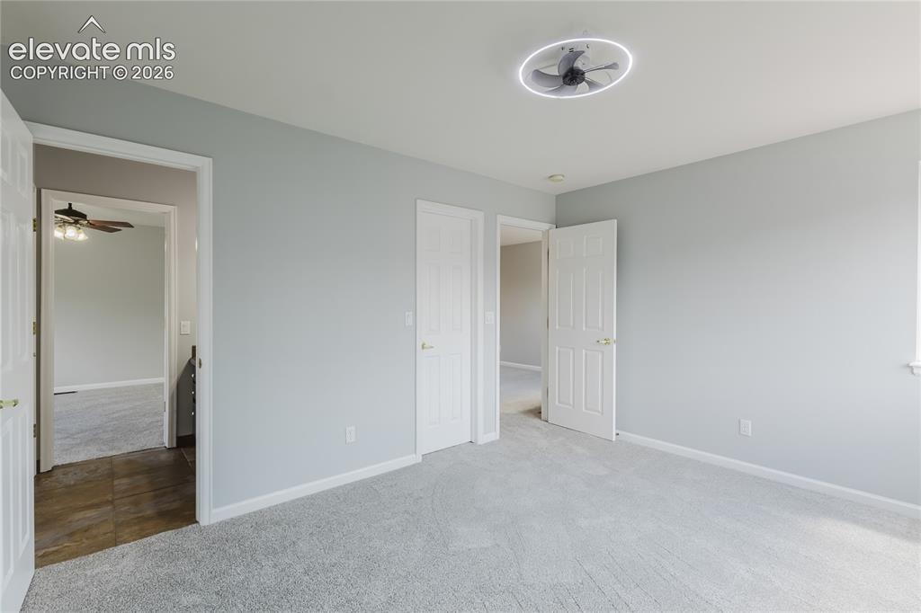 Image 29 of 46: Plush carpet flooring, light gray wall paint, a ceiling-mounted fan with in
