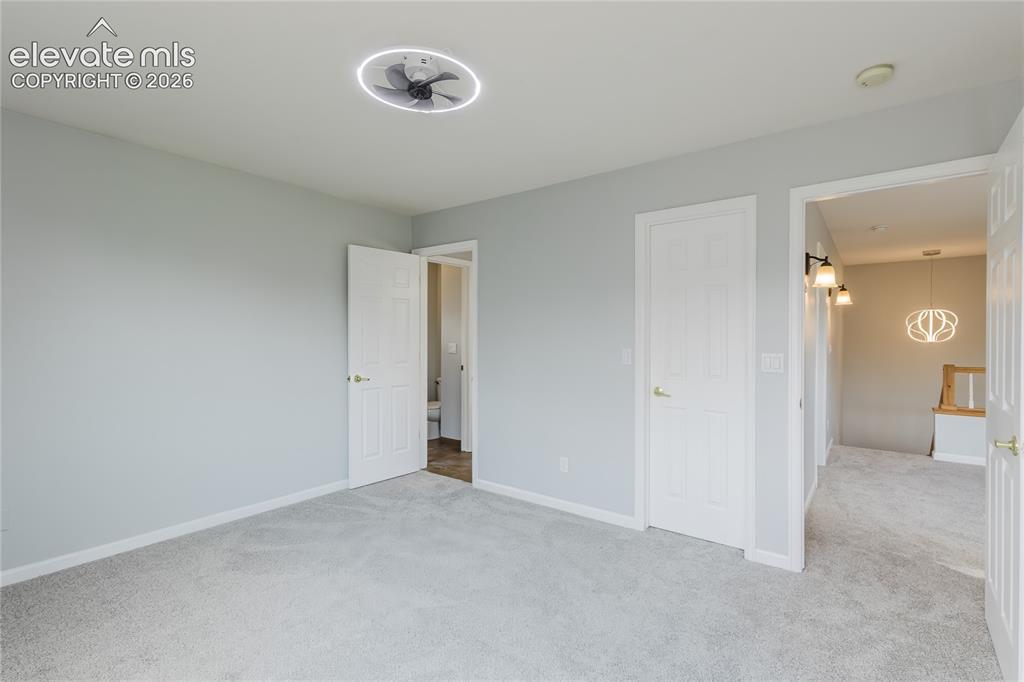 Image 30 of 46: Light gray wall finish, gray carpet flooring, contemporary ceiling fan, whi