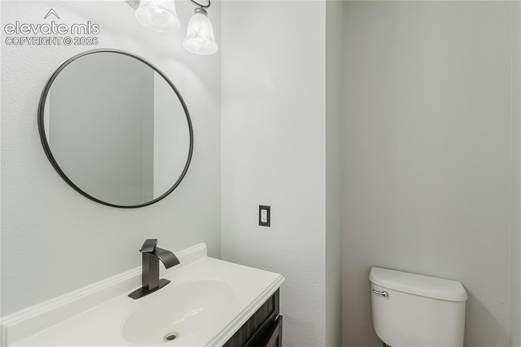 Image 34 of 46: Modern bathroom featuring a circular framed mirror with matte black finish,