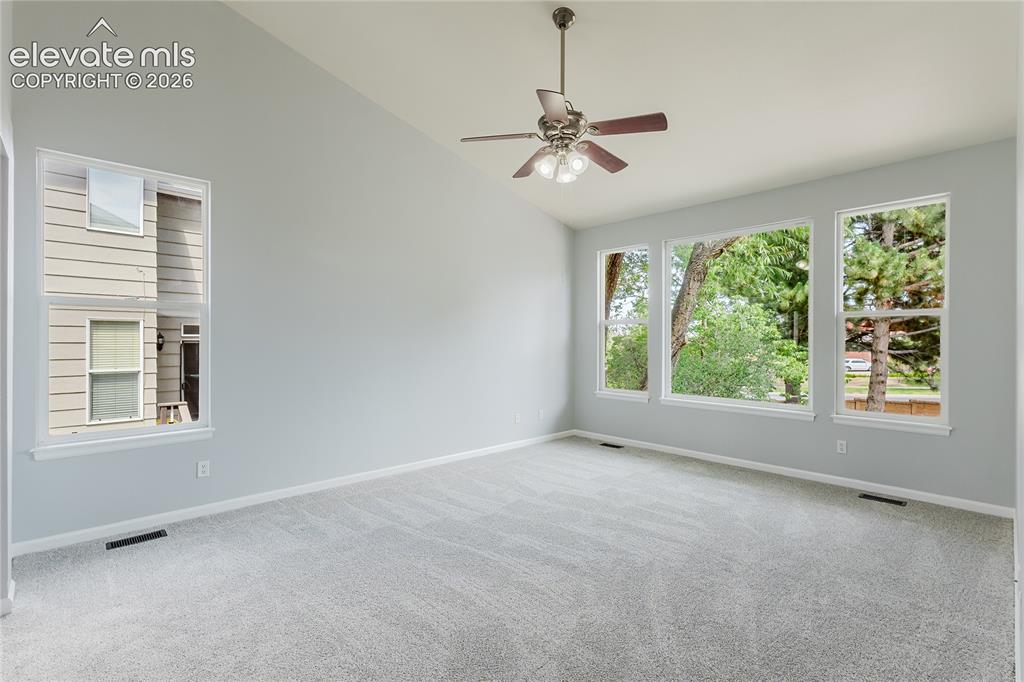 Image 38 of 46: Vaulted ceiling with a ceiling fan light fixture, light gray carpet, multip