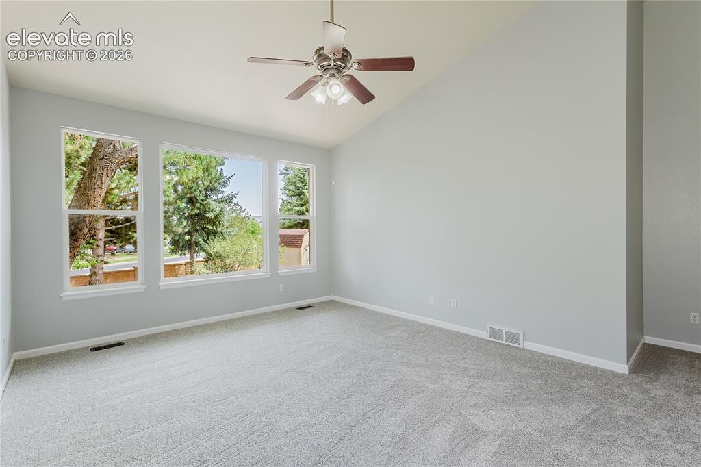 Image 39 of 46: Vaulted ceiling, ceiling fan with light fixture, light gray walls, light-to