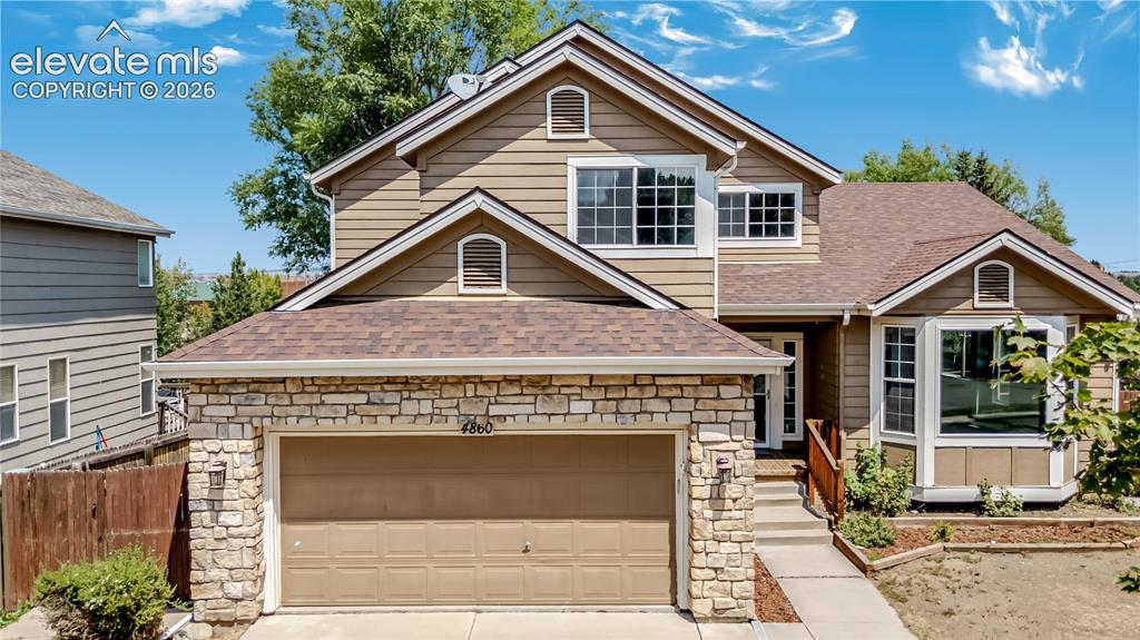 Image 46 of 46: Two-story residence featuring a stone and siding exterior, an attached two-