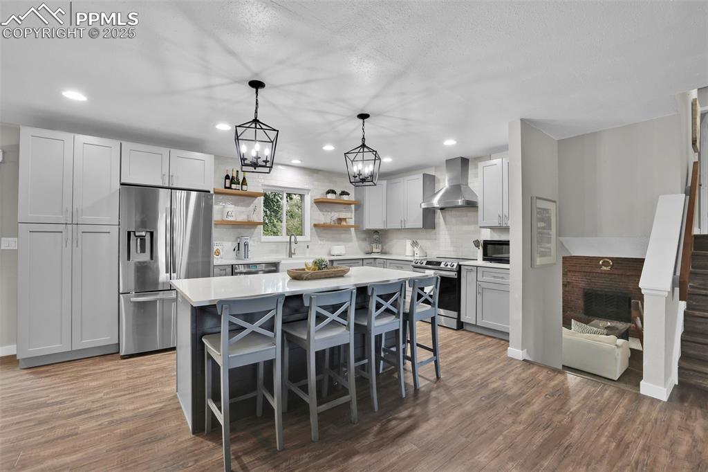 Image 17 of 50: Kitchen with decorative light fixtures, appliances with stainless steel fin