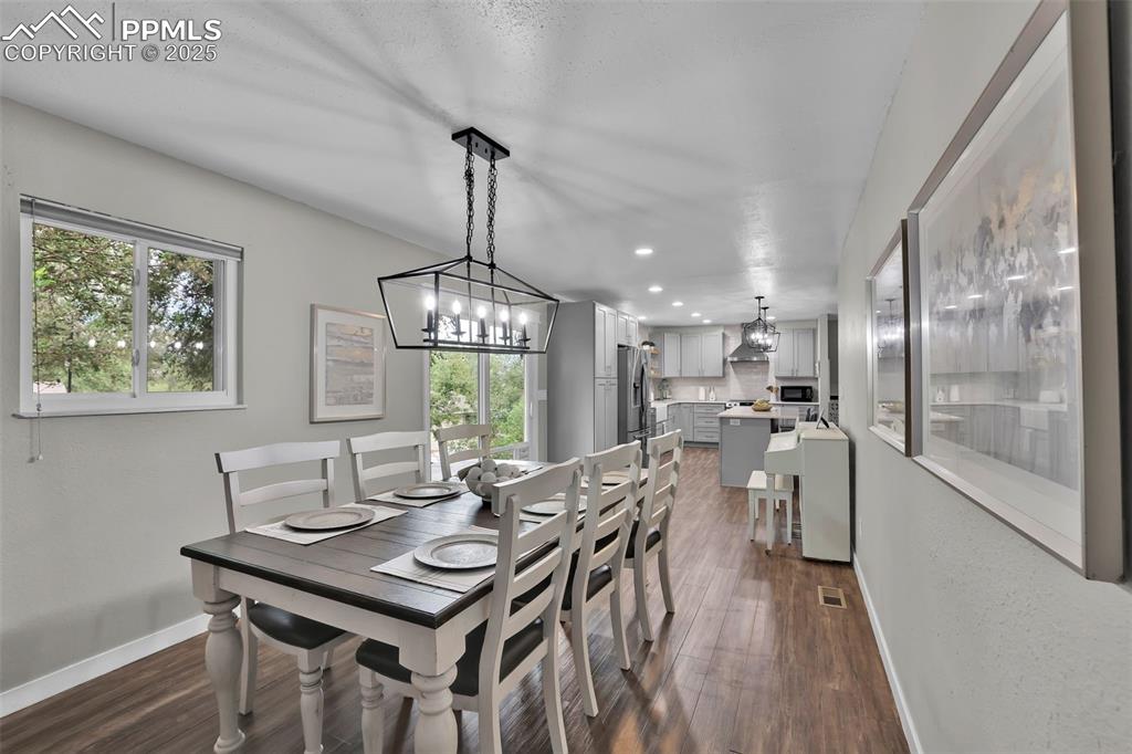 Image 22 of 50: Dining area featuring a chandelier, dark wood-type flooring, and recessed l