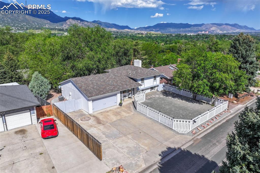 Image 3 of 50: Aerial view of property and surrounding area with a mountainous background 