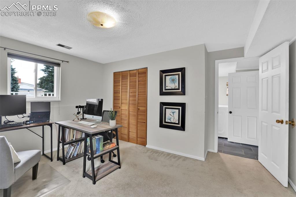 Image 38 of 50: Office area featuring light colored carpet and a textured ceiling