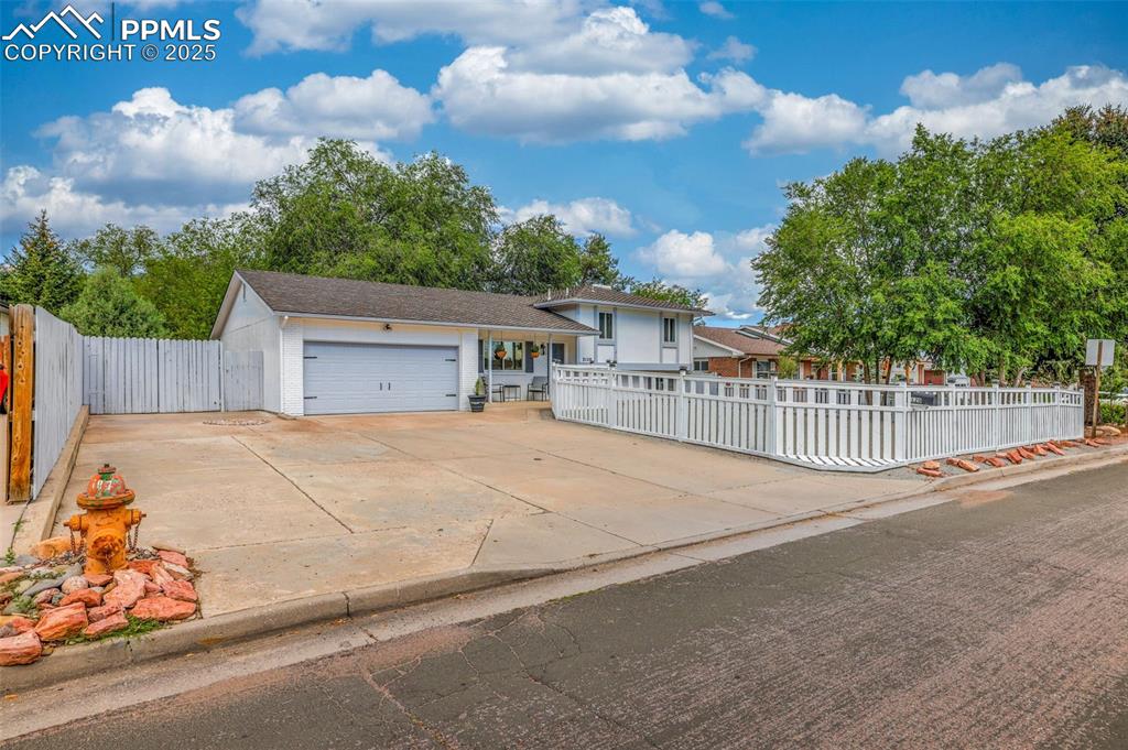 Image 8 of 50: View of front of property with a garage and driveway