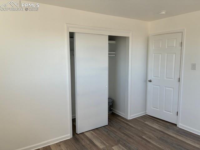 Image 10 of 36: Unfurnished bedroom featuring a closet and dark wood-type flooring
