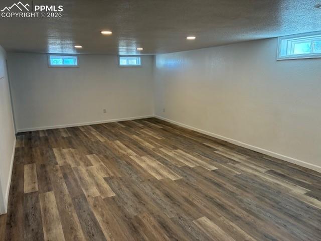 Image 16 of 36: Below grade area featuring healthy amount of natural light, dark wood finis