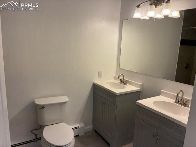 Image 17 of 36: Bathroom featuring two vanities, baseboard heating, and a textured wall